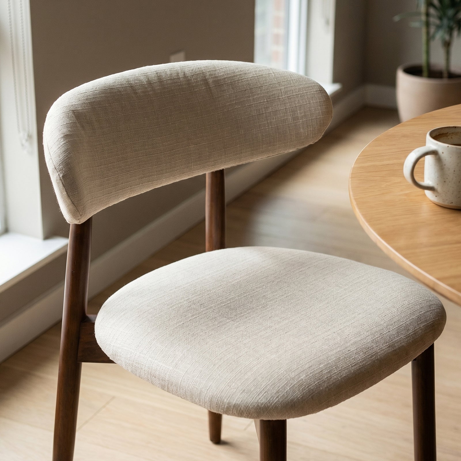 COLAMY NOYA beige upholstered dining chair with padded seat and wooden legs close-up