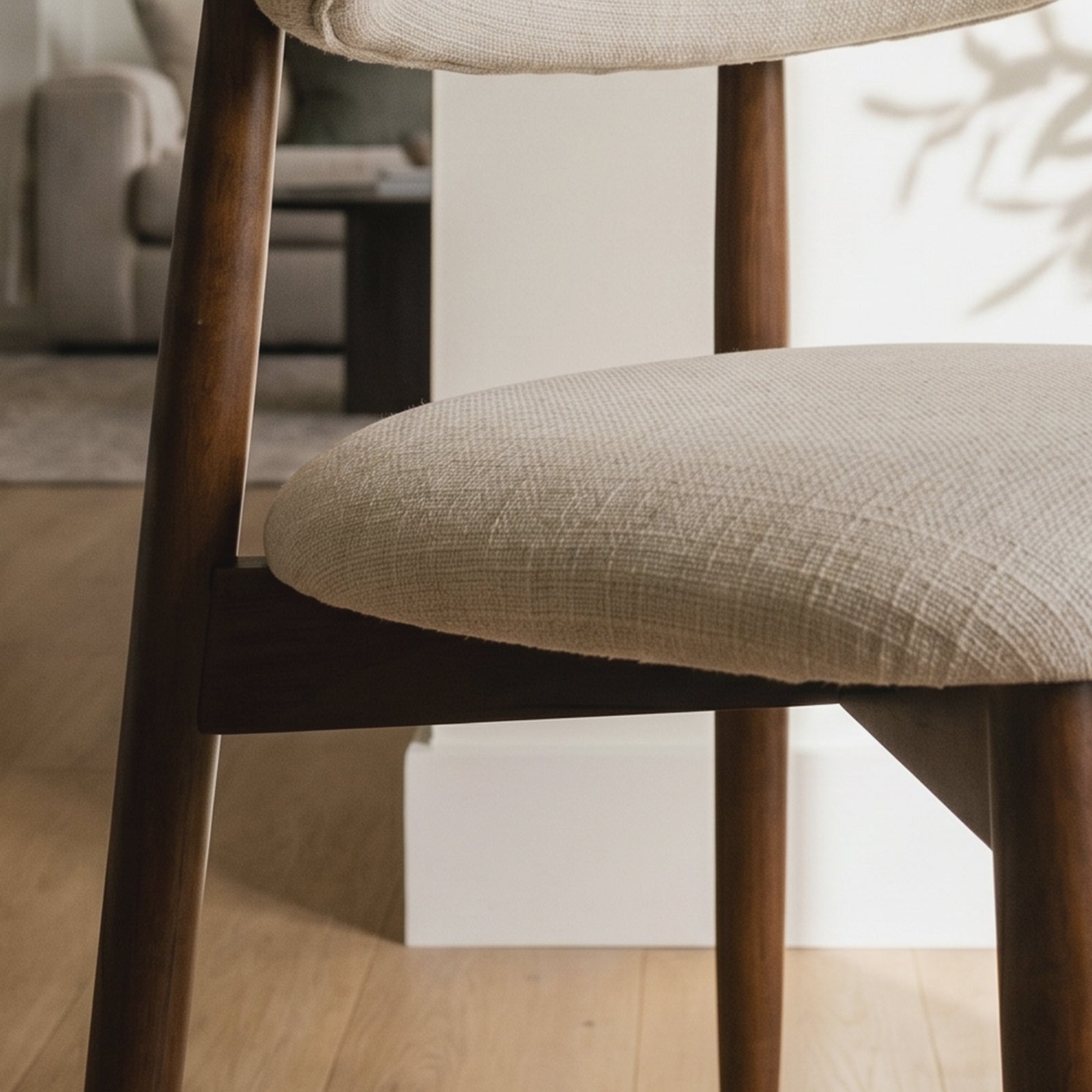 Close-up of COLAMY NOYA beige fabric seat cushion and wooden dining chair frame