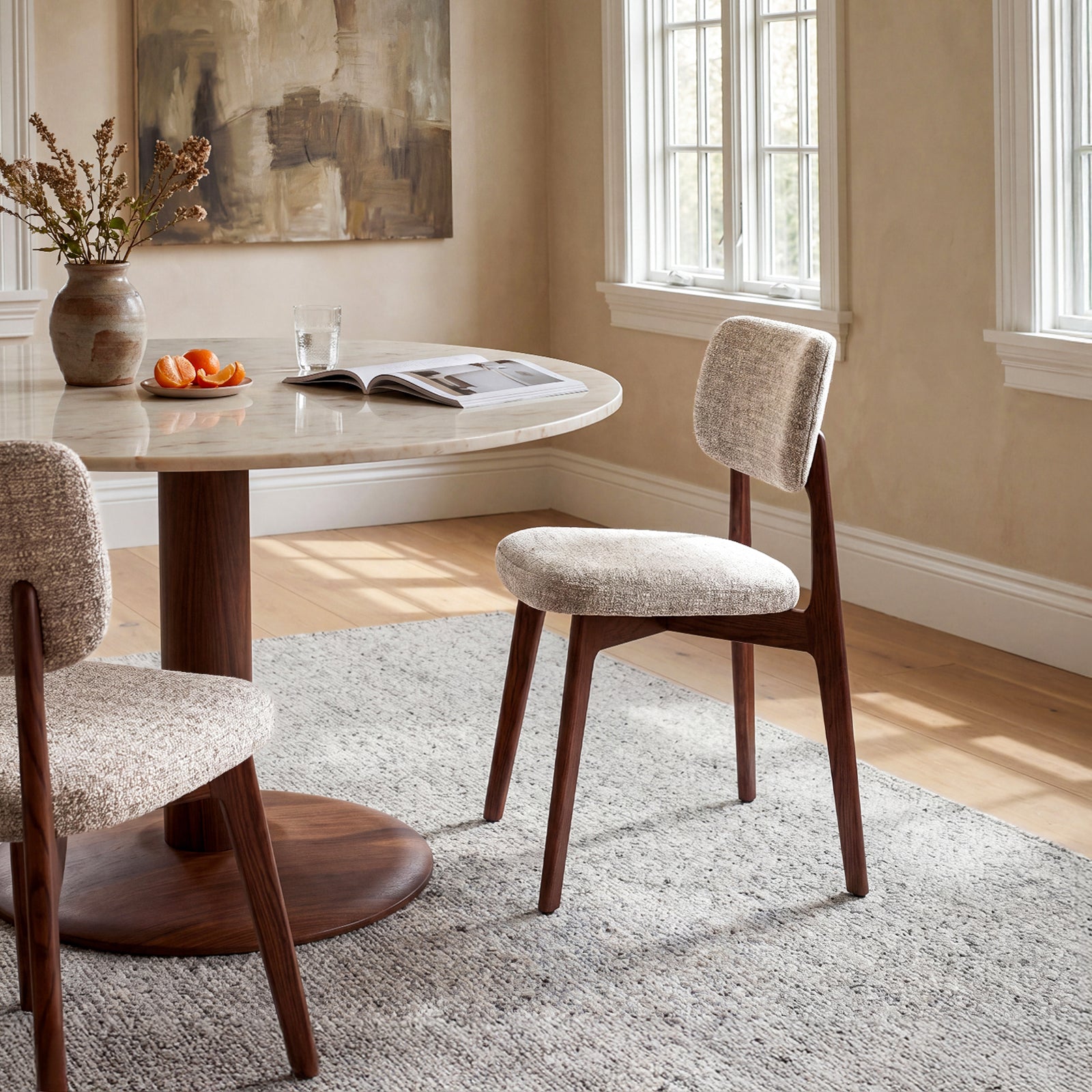 HALO Prime upholstered dining chairs with walnut wood frames beside a round dining table